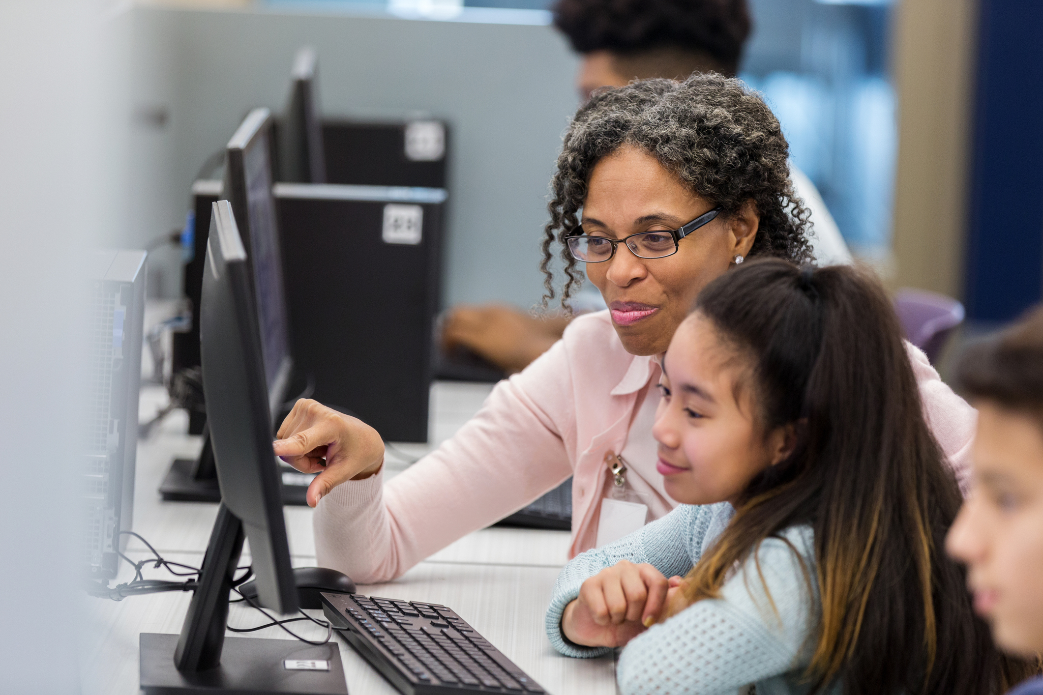 Teacher helps students in computer lab