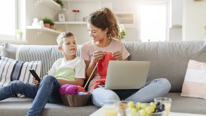 Mom knitting with son on couch