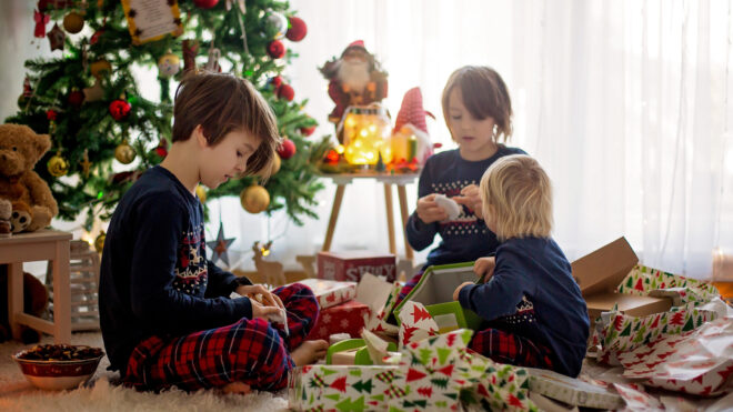 Happy children, boys, opening presents on christmas day, dressed in pajamas