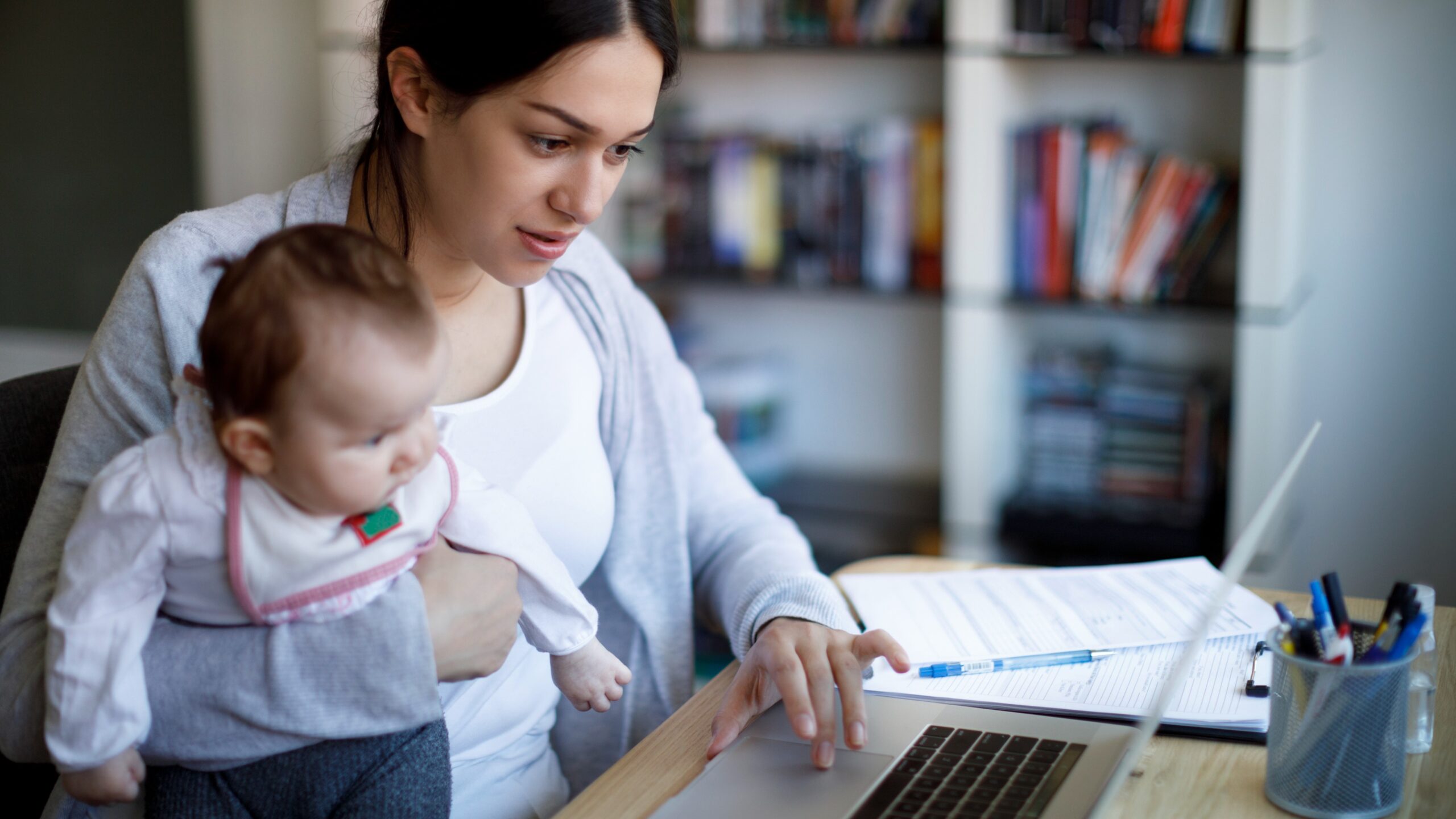 woman holding baby on the computer