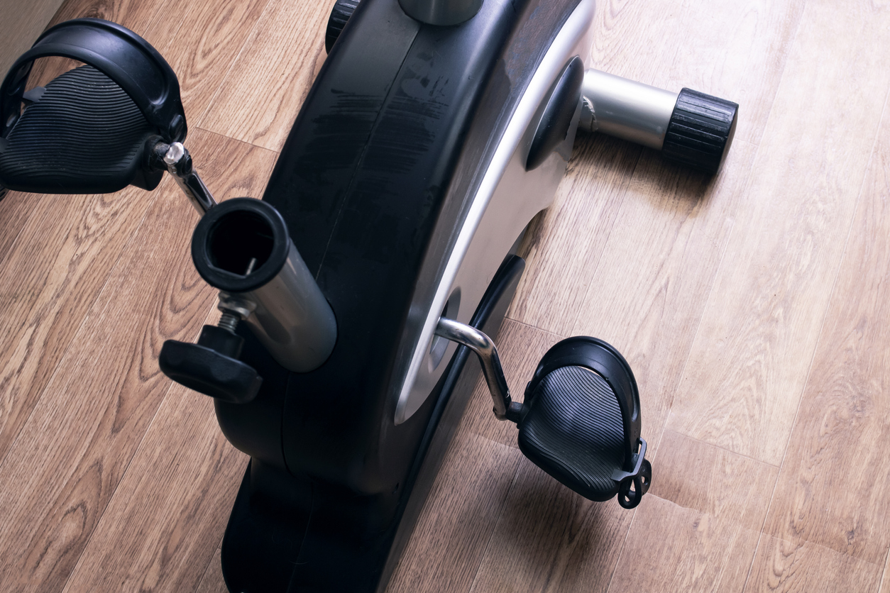 Exercise bike pedals on wood floor background