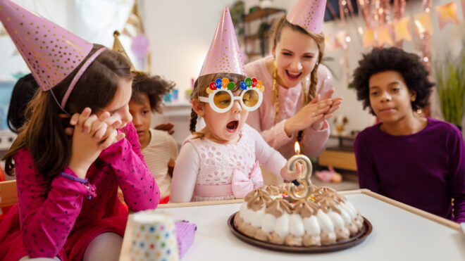 Little girl blowing her birthday candle