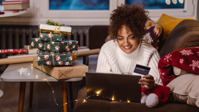 Young woman using credit card and laptop while shopping online