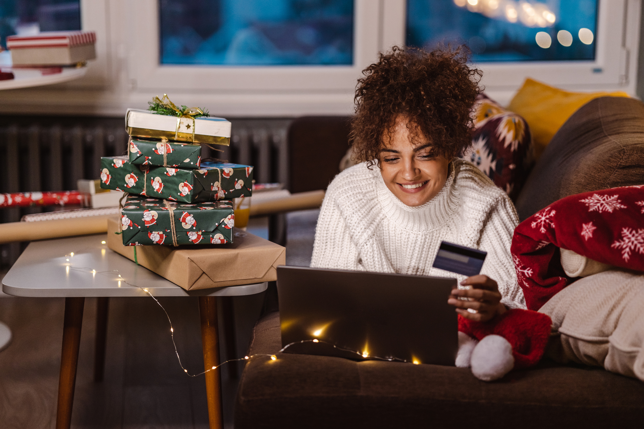 Young woman using credit card and laptop while shopping online