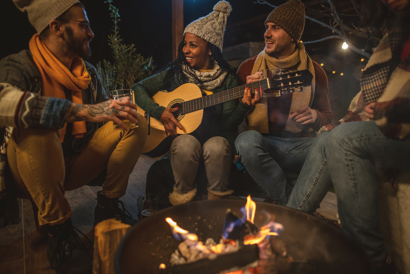 People playing music by a campfire