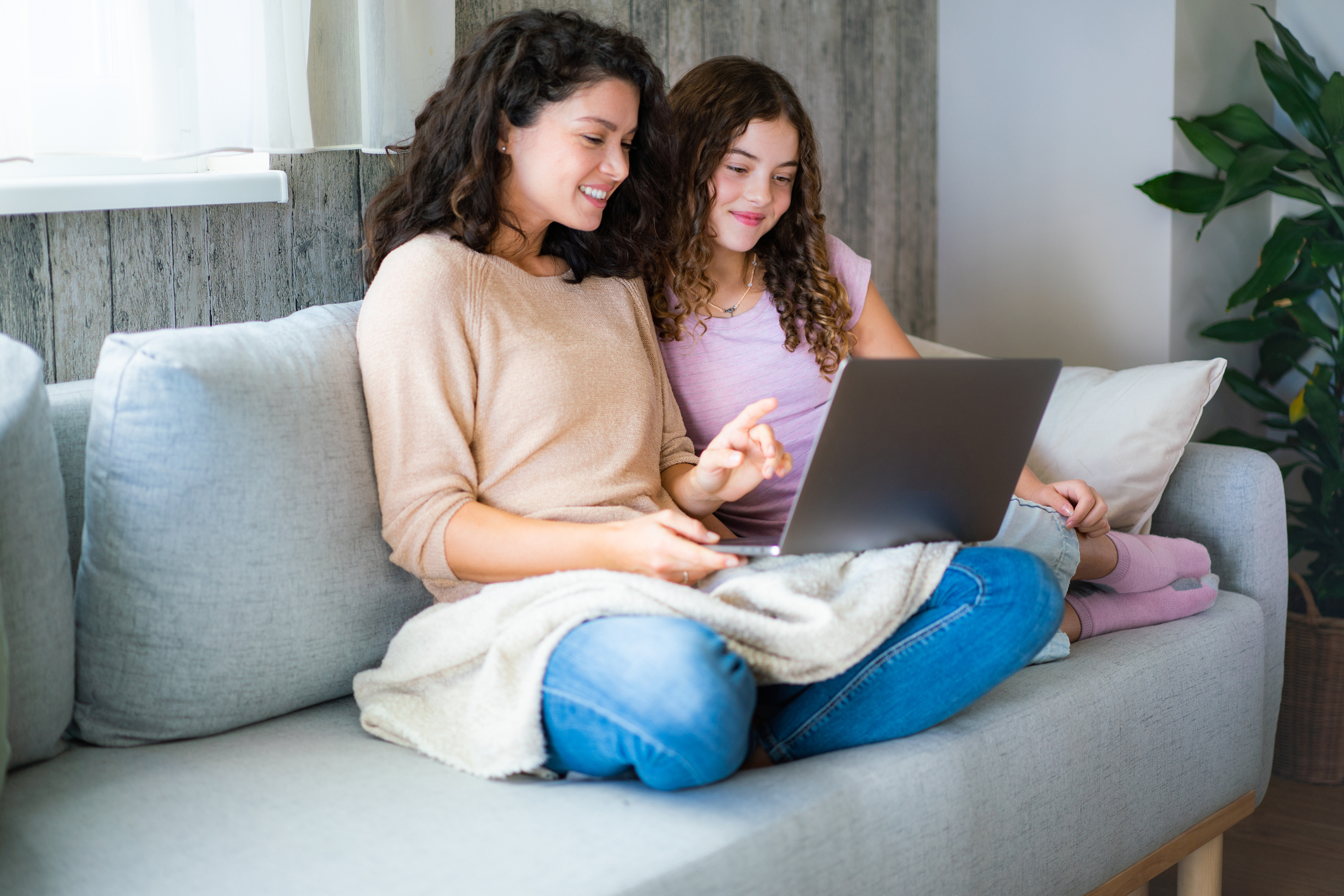 Mother and daughter using a laptop together at home