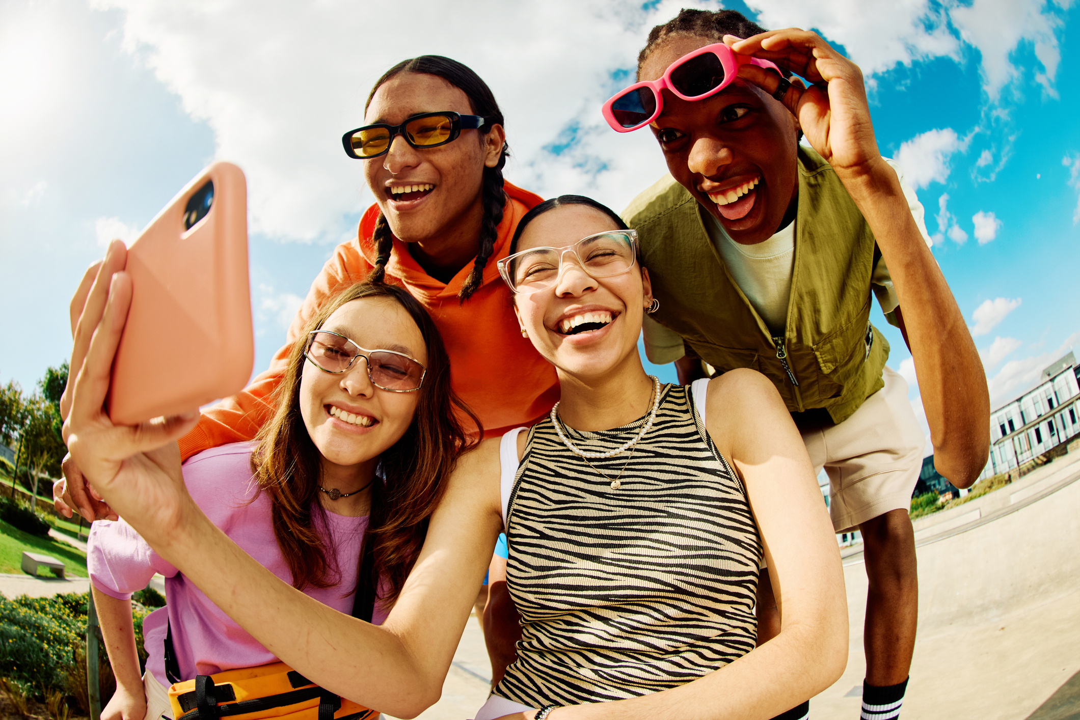 Wide angle shot of Gen Z group of friends using a smartphone together.