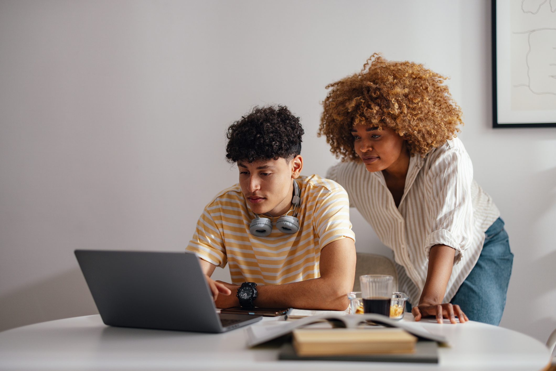 Mother and Teen Son Working Together on Laptop at Home