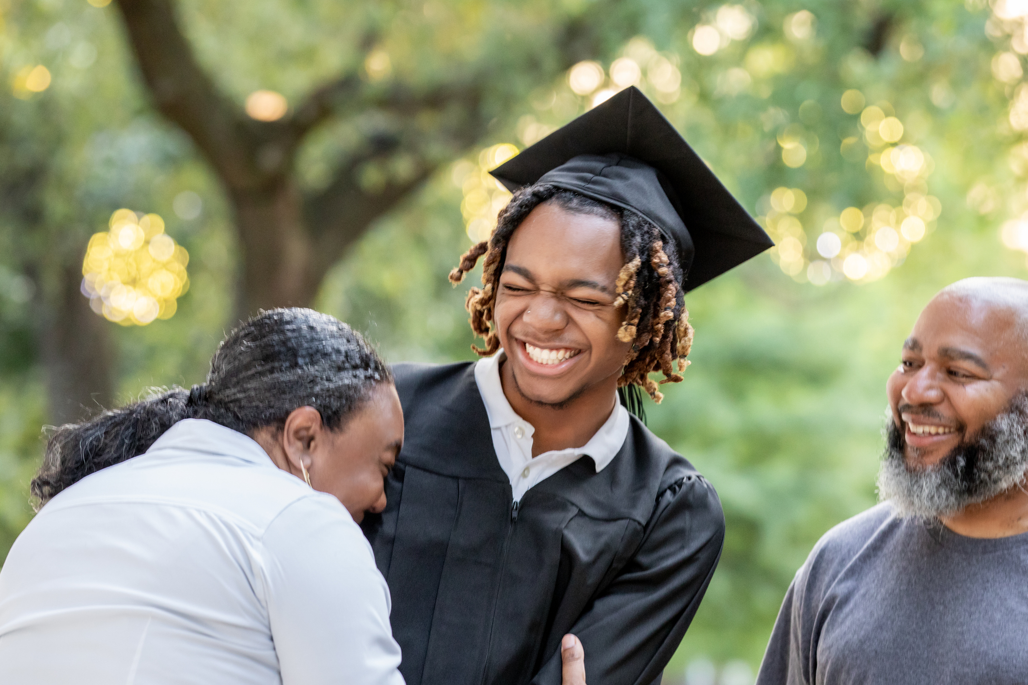 A mother and her son share a smile and a laugh as they prepare for his graduation ceremony.