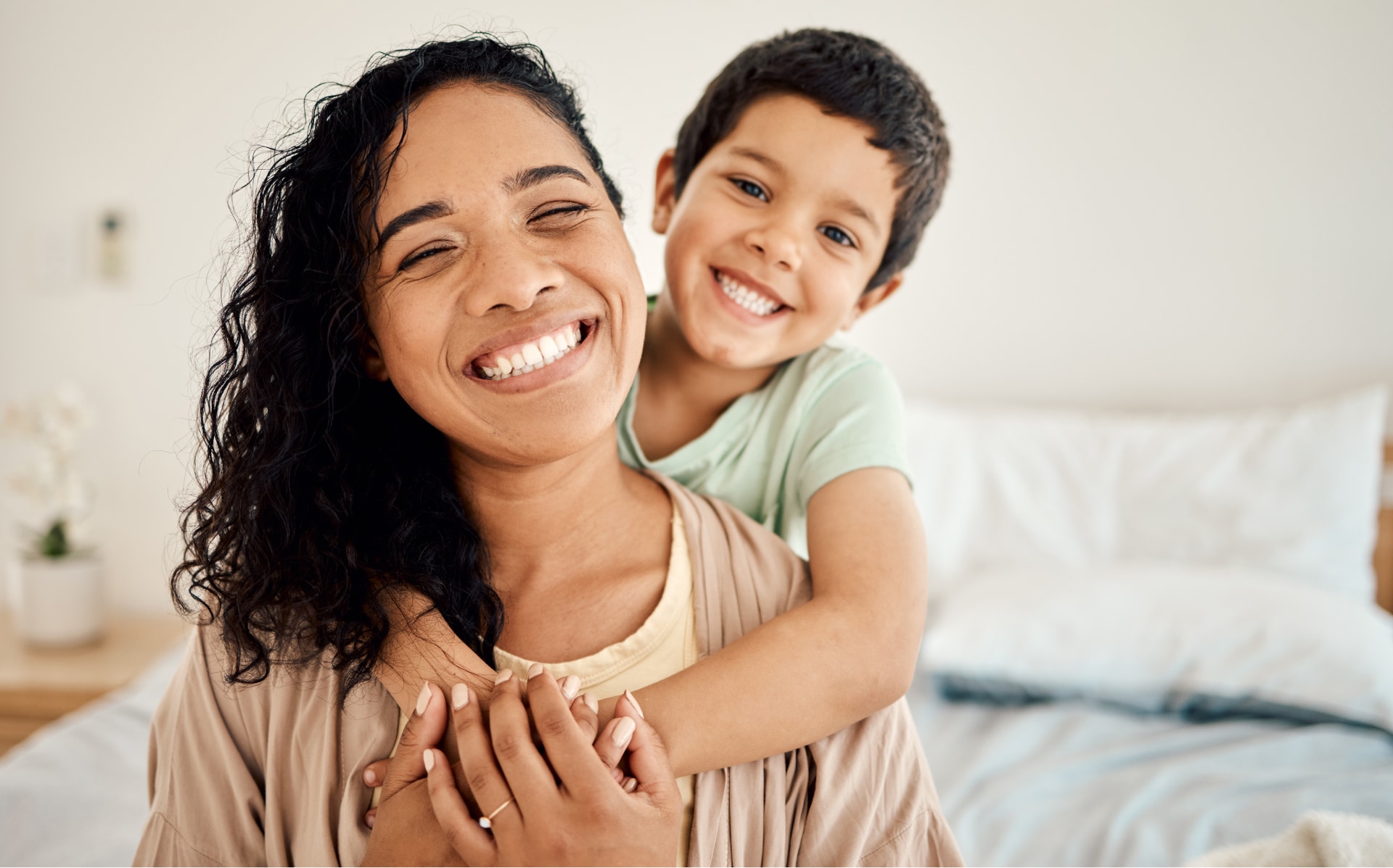 Smiling mom with child hanging on her back