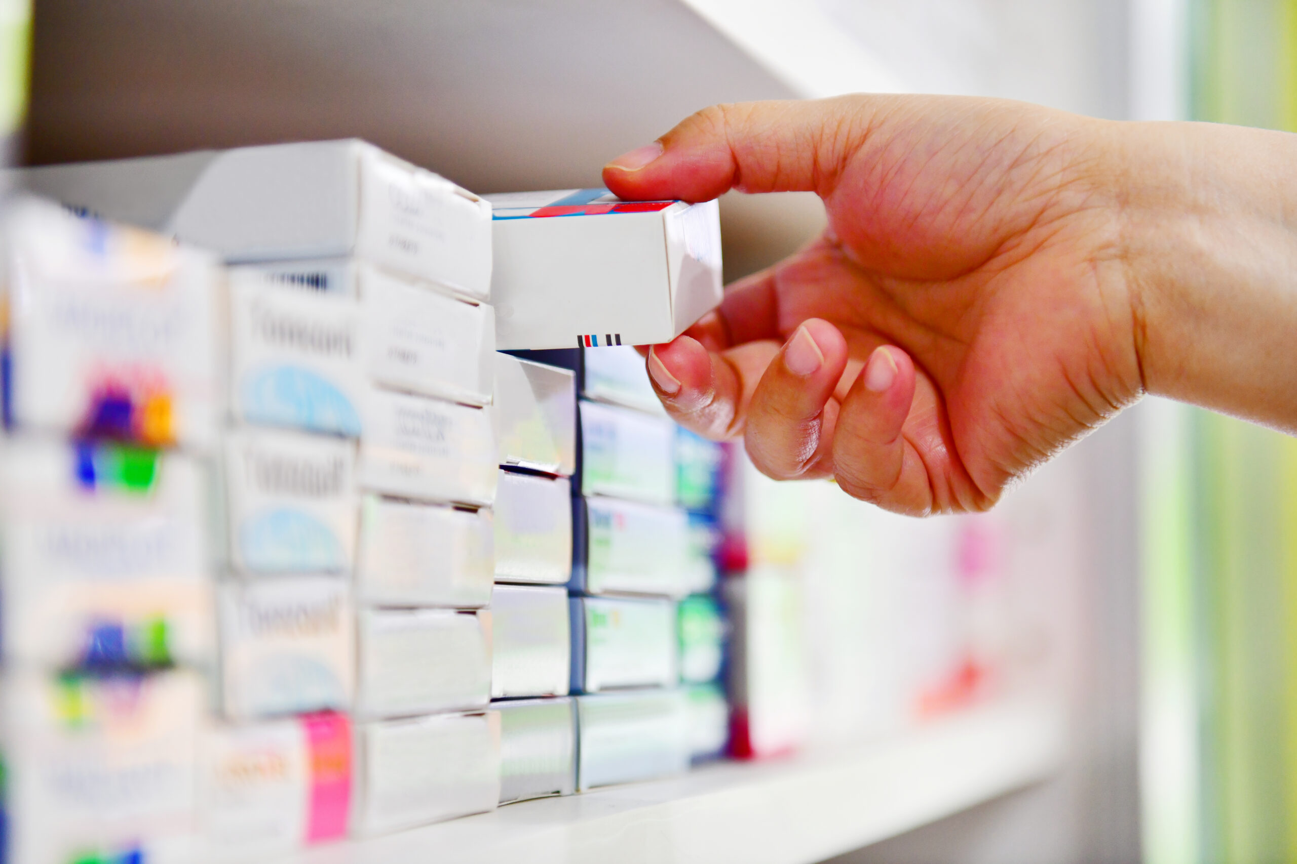 Hand holding medicine box in pharmacy drugstore.