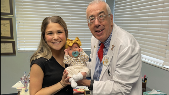 Ashley Wells poses with Dr. John White and her baby