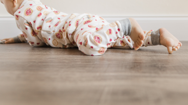 a baby with bare feet in two piece holiday pajamas