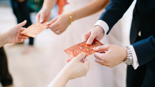 hands of married couple receiving cards from guests